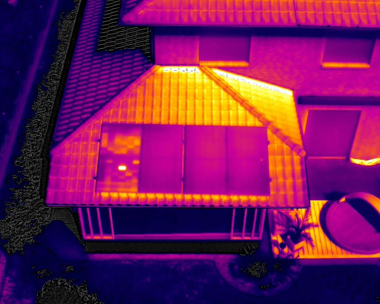 Drohnengestützte Thermografieaufnahme eines Dachbereichs mit Photovoltaikmodulen aus der Vogelperspektive