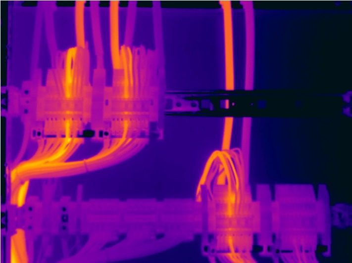 Thermografieaufnahme einer Niederspannungsverteilung mit deutlich erwärmten Leitungen und Klemmstellen